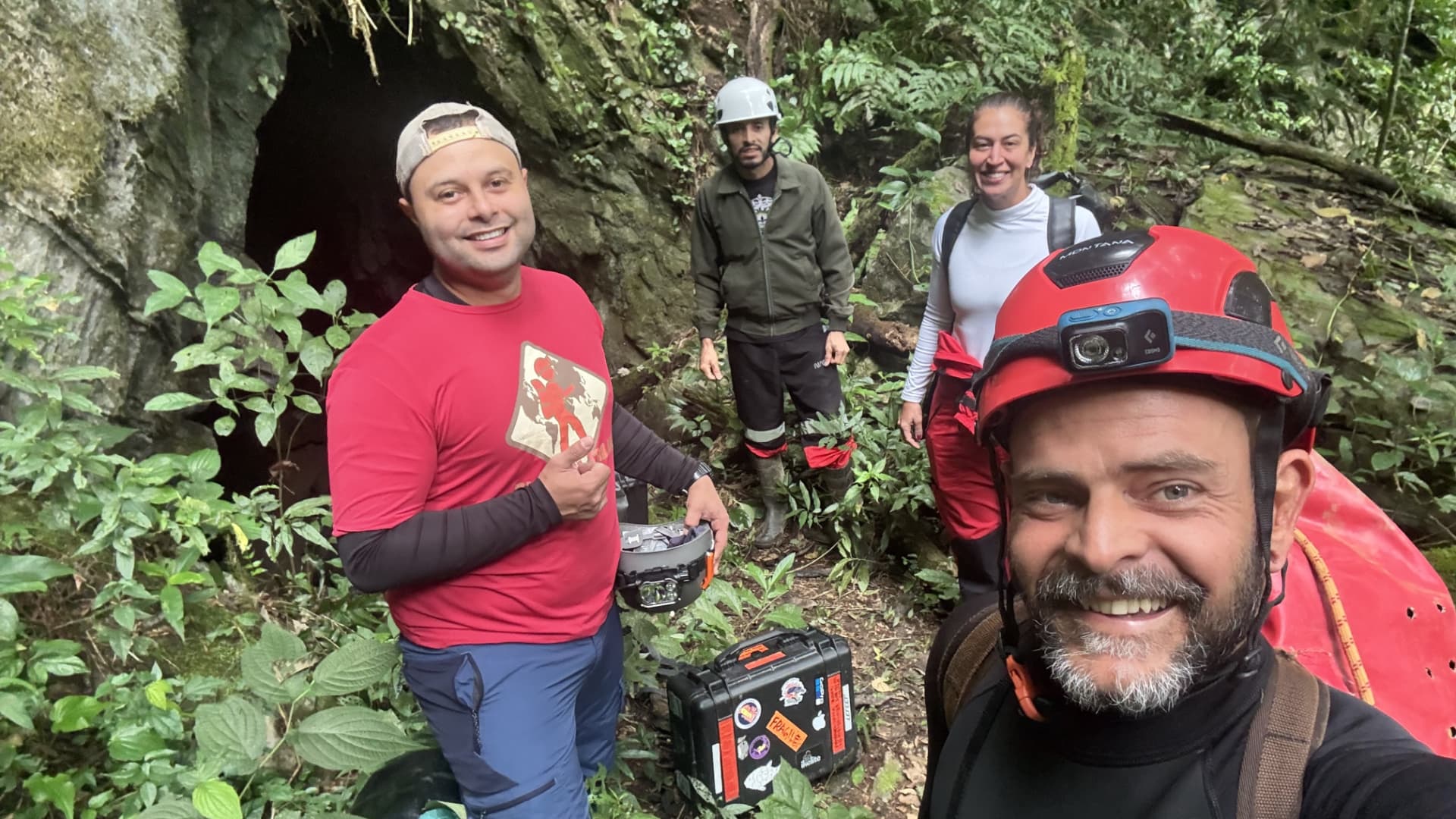 Expedition team with helmets and equipment at the cave entrance