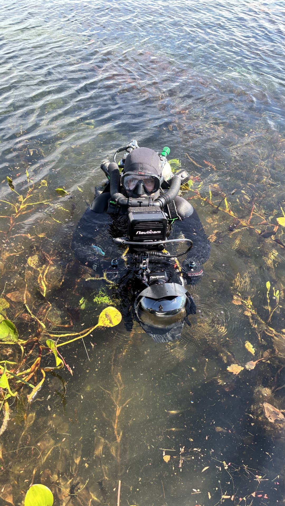 Filmmaker in diving gear getting ready to enter the water